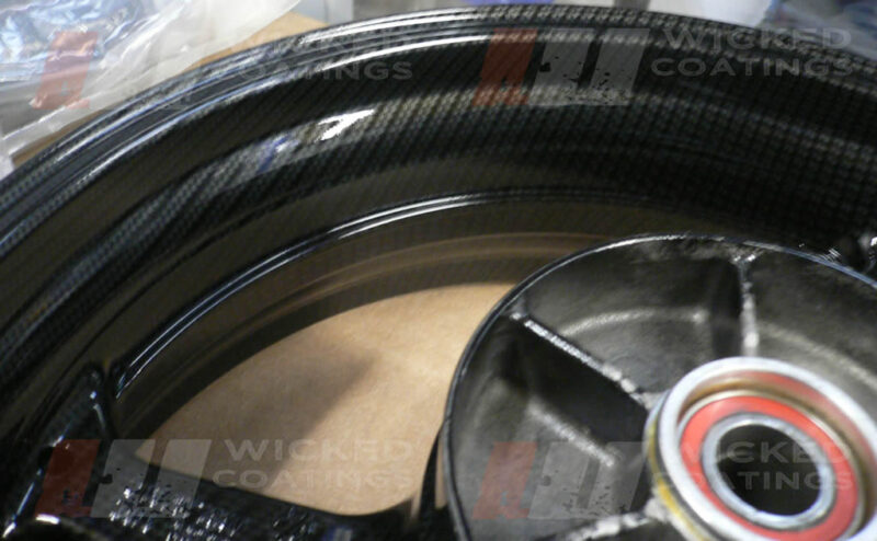 Close up of carbon dipping on Honda CBR 600 motorcycle rear wheel