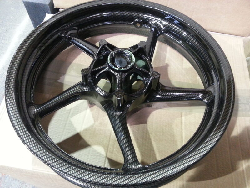 Motorbike alloy wheels coated in carbon fibre painted black