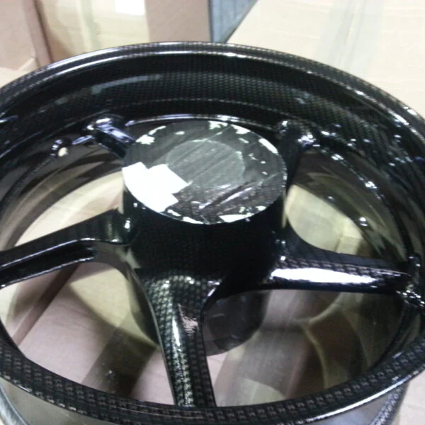 Motorbike alloy wheels coated in carbon fibre painted black