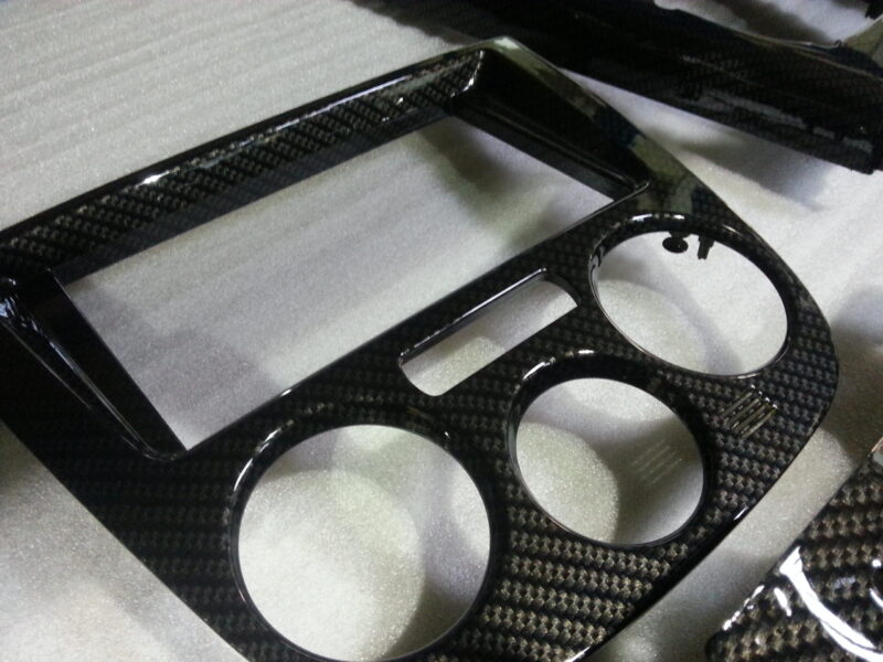 Parts of dashboard coated in carbon fibre