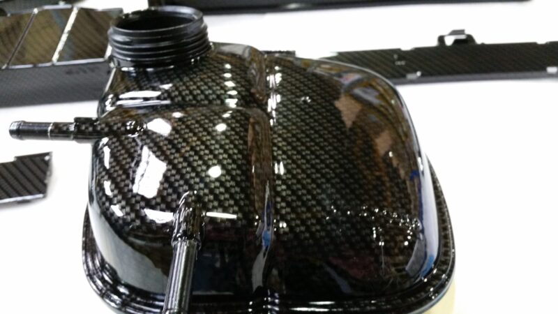 Car engine elements coated in carbon fibre hydrographic film painted black