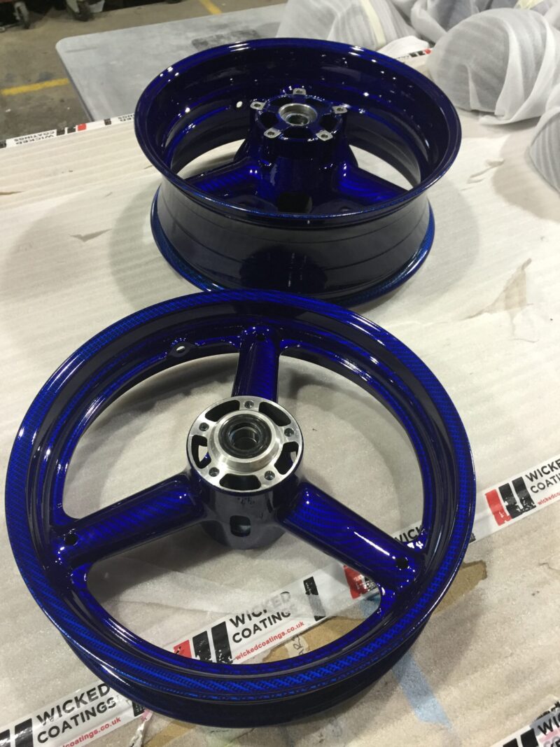 Motorbike wheels coated in carbon fibre painted dark blue