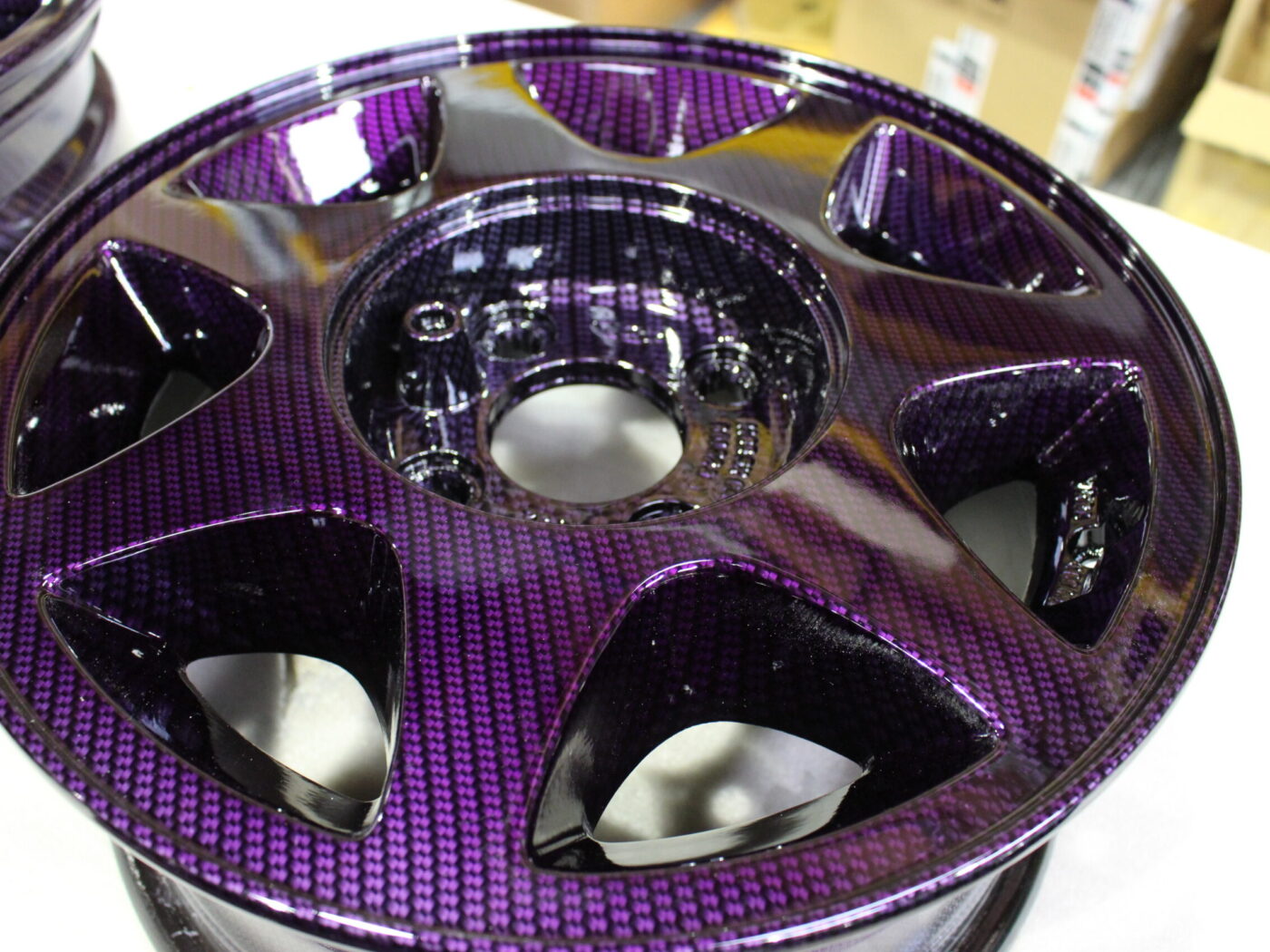 Car alloy wheels coated in carbon fibre painted magenta