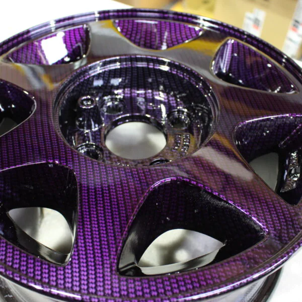 Car alloy wheels coated in carbon fibre painted magenta