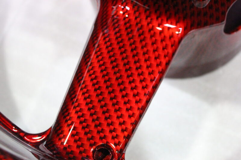 Motorbike alloy wheels coated in carbon fibre painted dark red