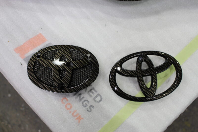 Radiator cover coated in carbon fibre