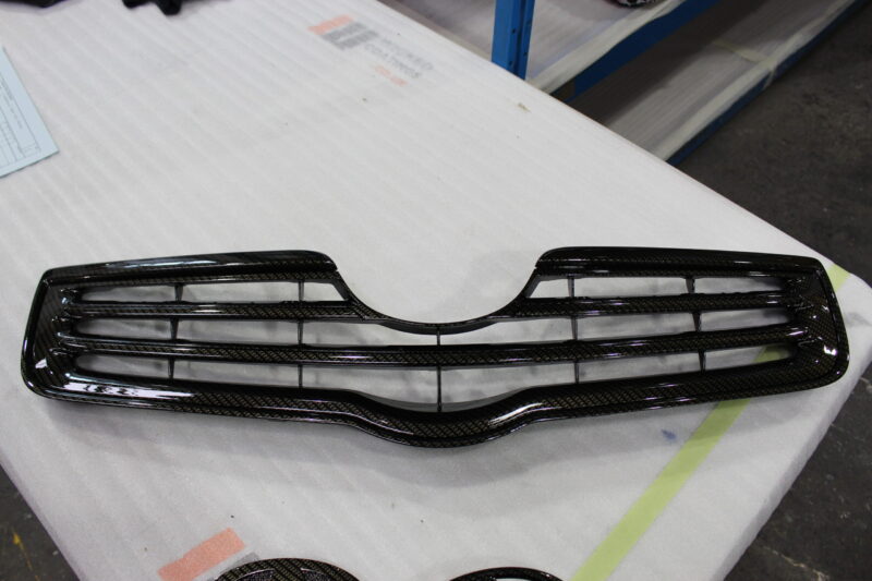 Radiator cover coated in carbon fibre