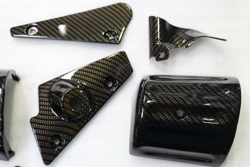 Various car exterior coated in carbon fibre