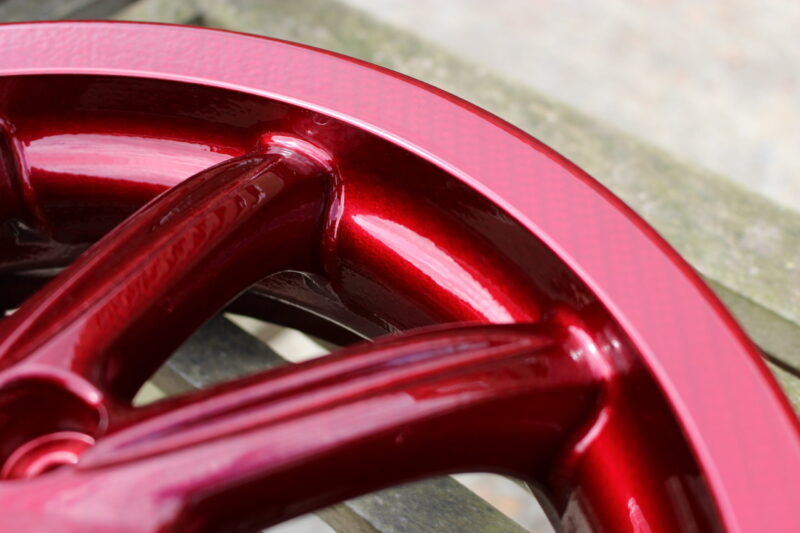 Car alloy wheels coated in carbon fibre painted red