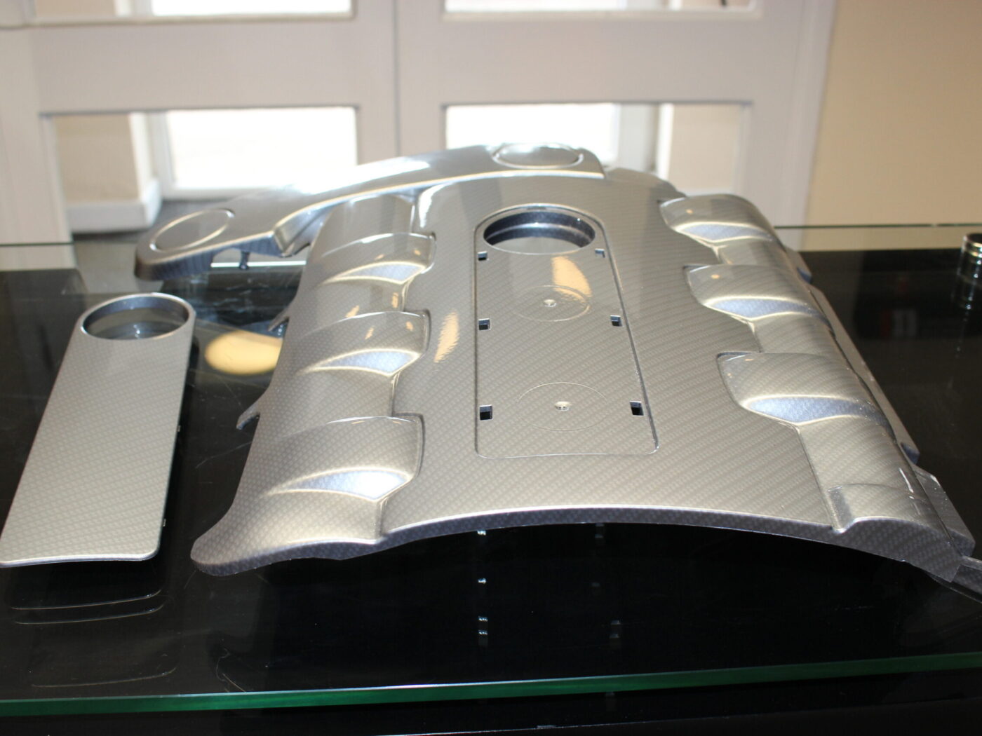 Car engine element coated in carbon fibre painted silver