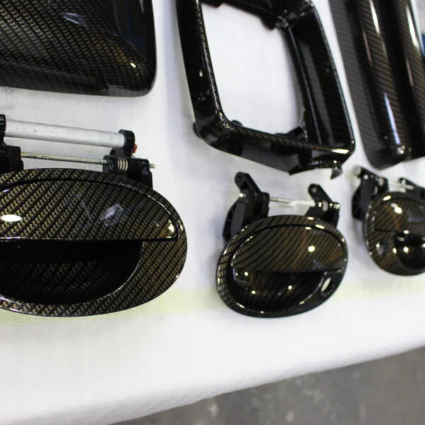 Various car interior parts coated in carbon fibre