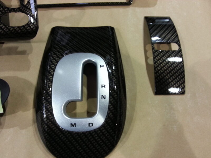 Car interior part coated in carbon fibre hydrographic film painted black