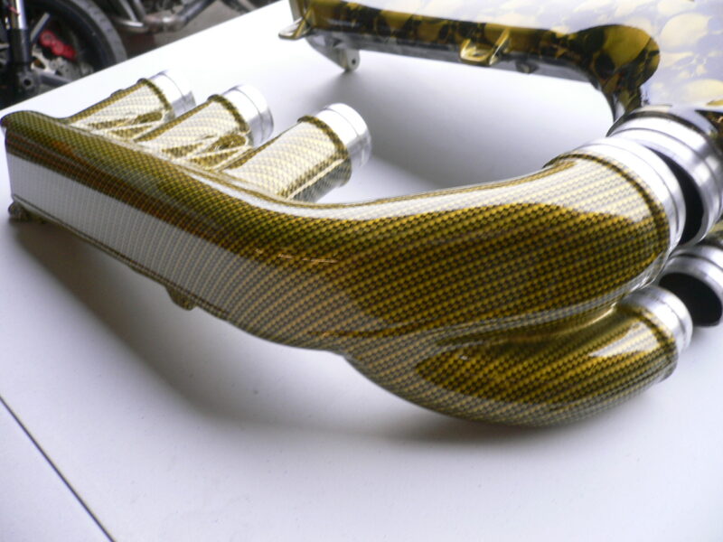 Car engine part coated in skull and carbon fibre painted yellow