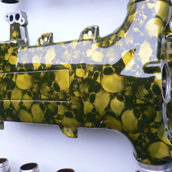 Car engine part coated in skull and carbon fibre painted yellow