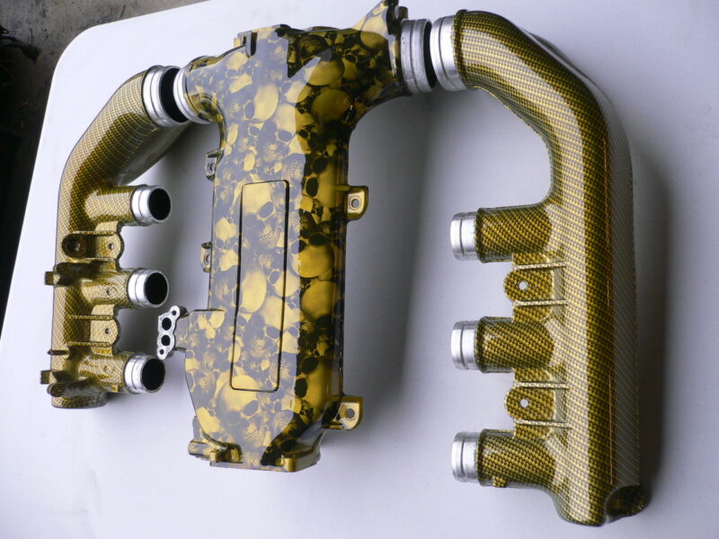 Car engine part coated in skull and carbon fibre painted yellow