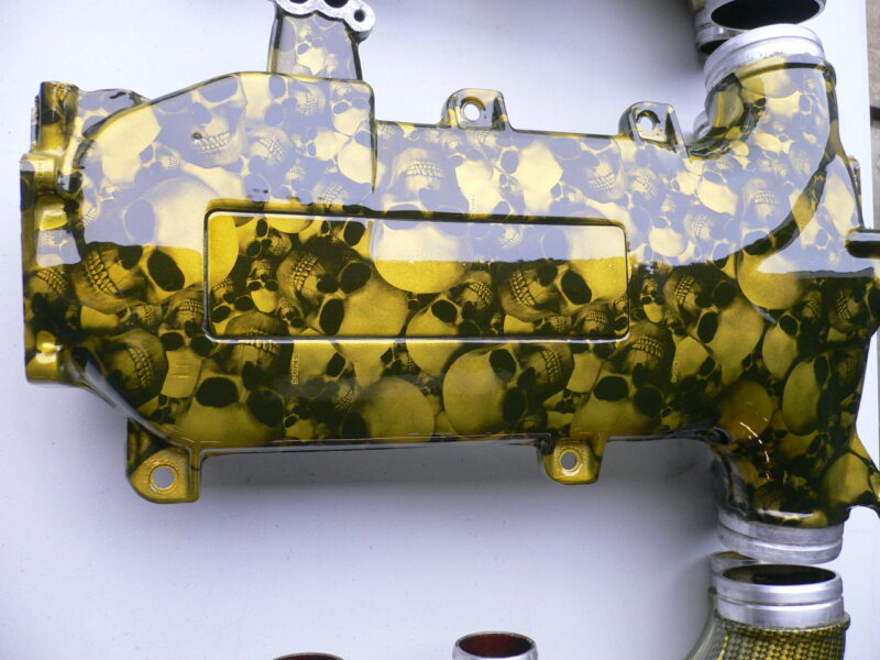 Car engine part coated in skull and carbon fibre painted yellow