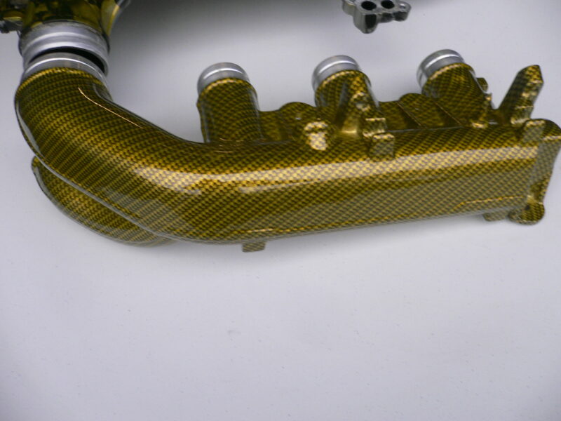 Car engine part coated in skull and carbon fibre painted yellow