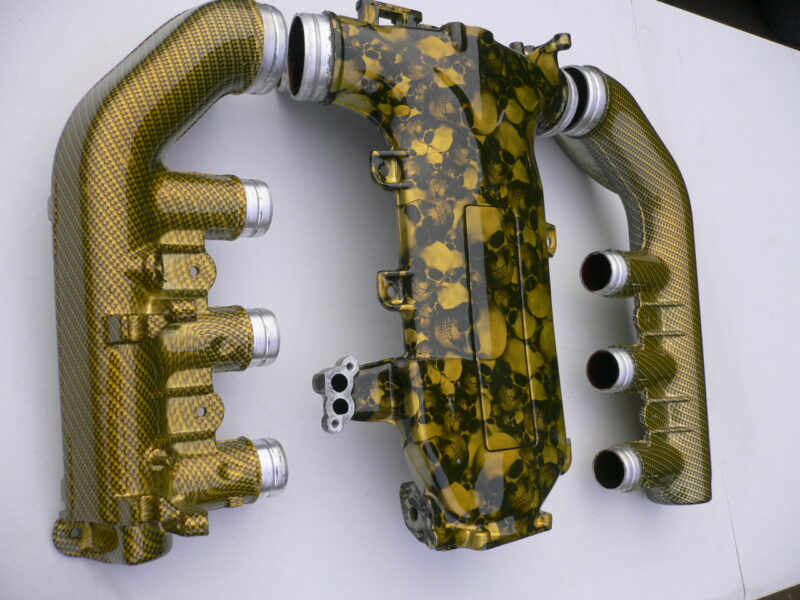 Car engine part coated in skull and carbon fibre painted yellow