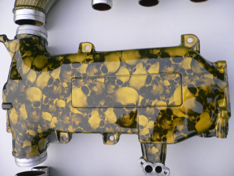 Car engine part coated in skull and carbon fibre painted yellow