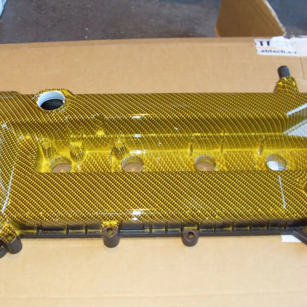 Car engine parts coated in carbon fibre painted yellow