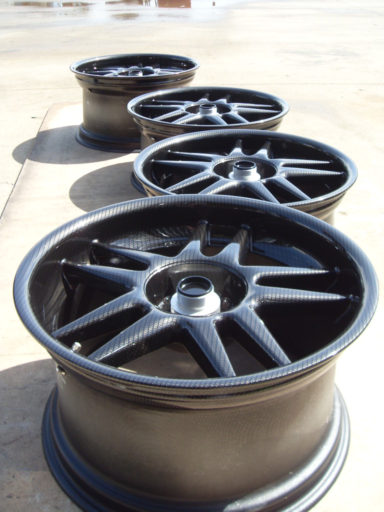 Car alloy wheels coated in carbon fibre painted black and green
