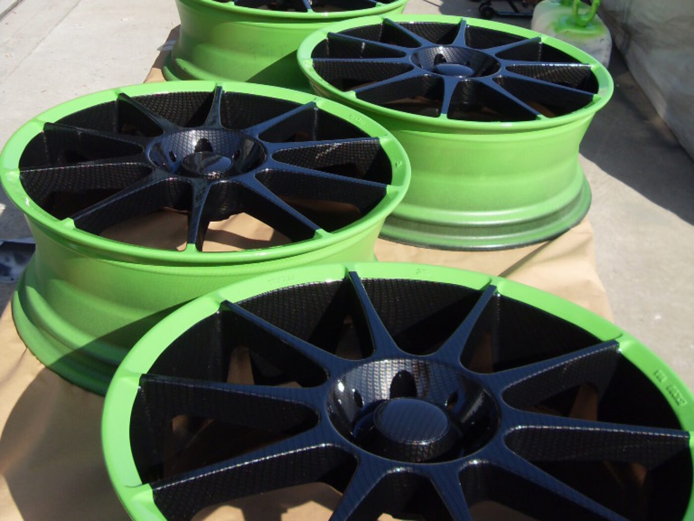 Car alloy wheels coated in carbon fibre painted black and green