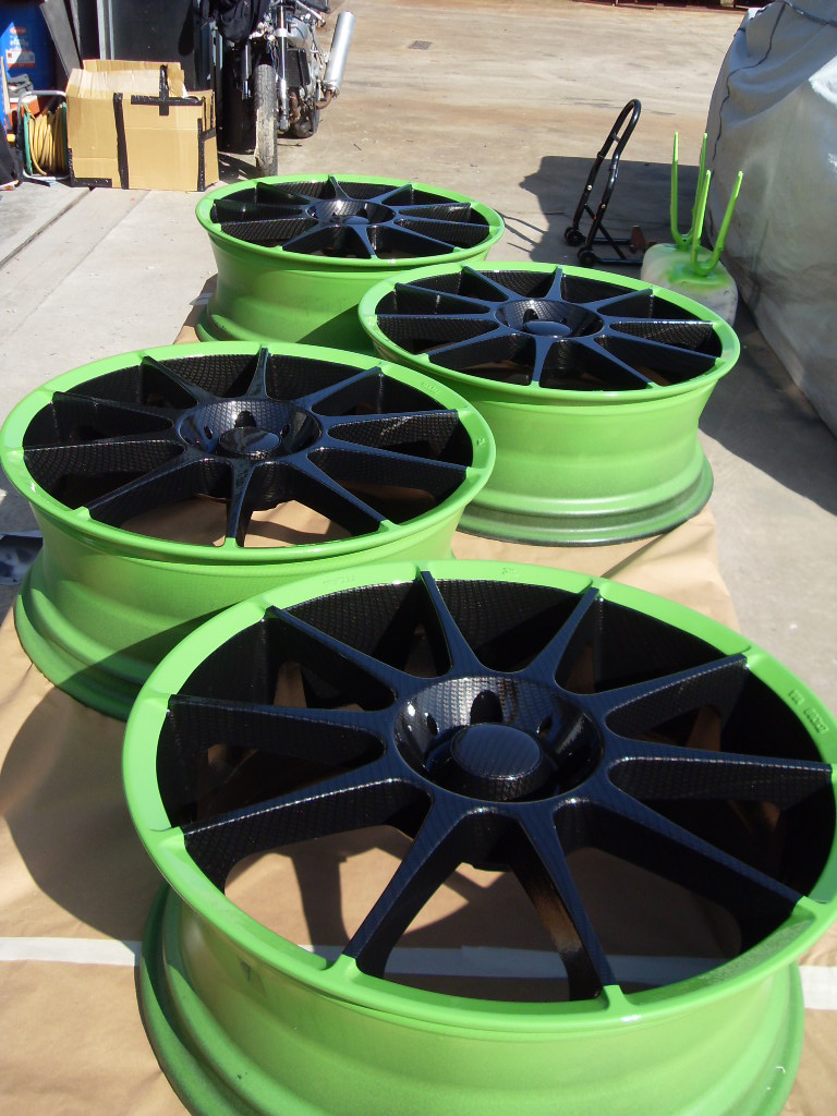 Car alloy wheels coated in carbon fibre painted black and green