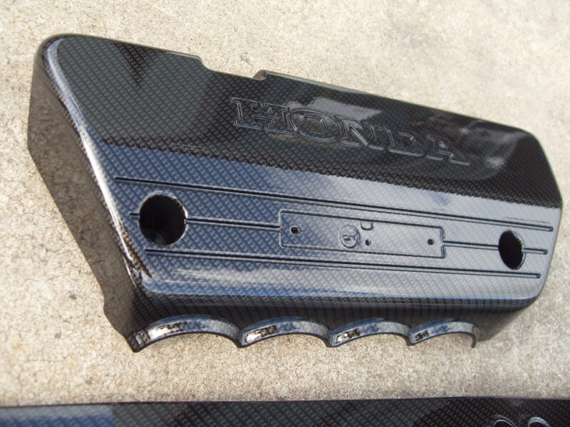 Honda engine cover coated in carbon fibre hydrographic film painted black