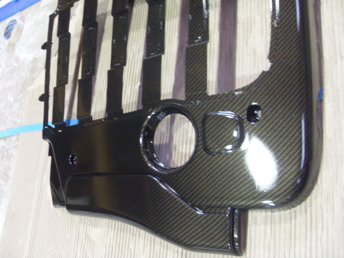 Car engine cover coated in carbon fibre hydrographic film painted black