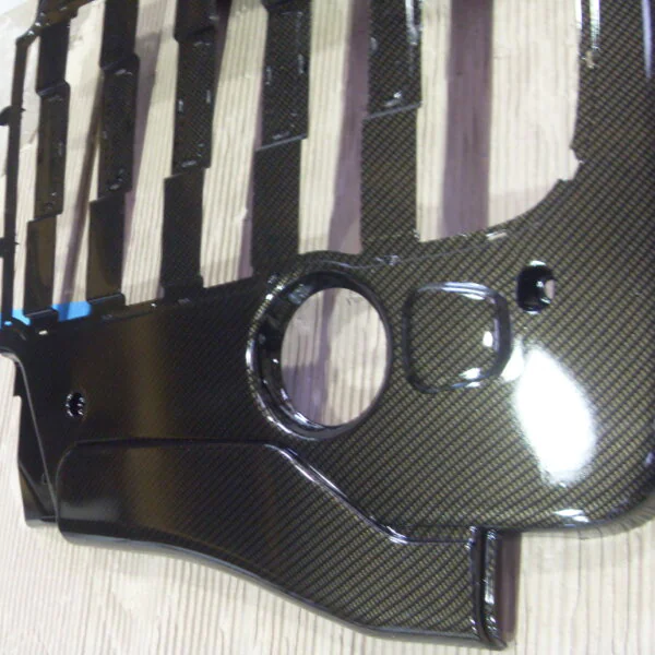 Car engine cover coated in carbon fibre hydrographic film painted black