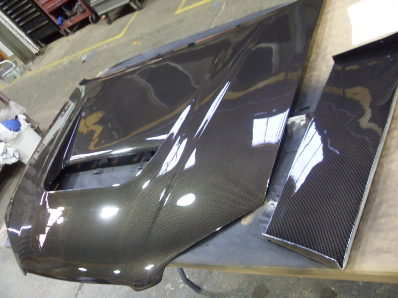 Car hood coated in carbon fibre hydrographic film painted black