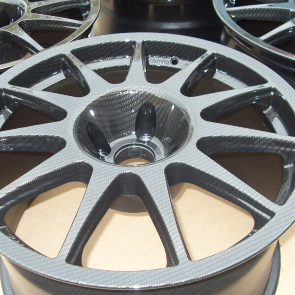 Car alloy wheels coated in carbon fibre painted black