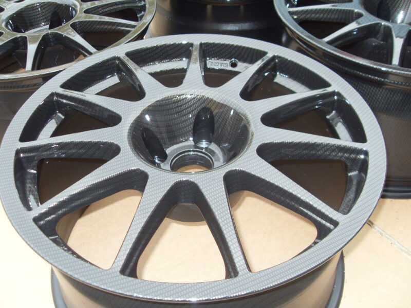 Car alloy wheels coated in carbon fibre painted black