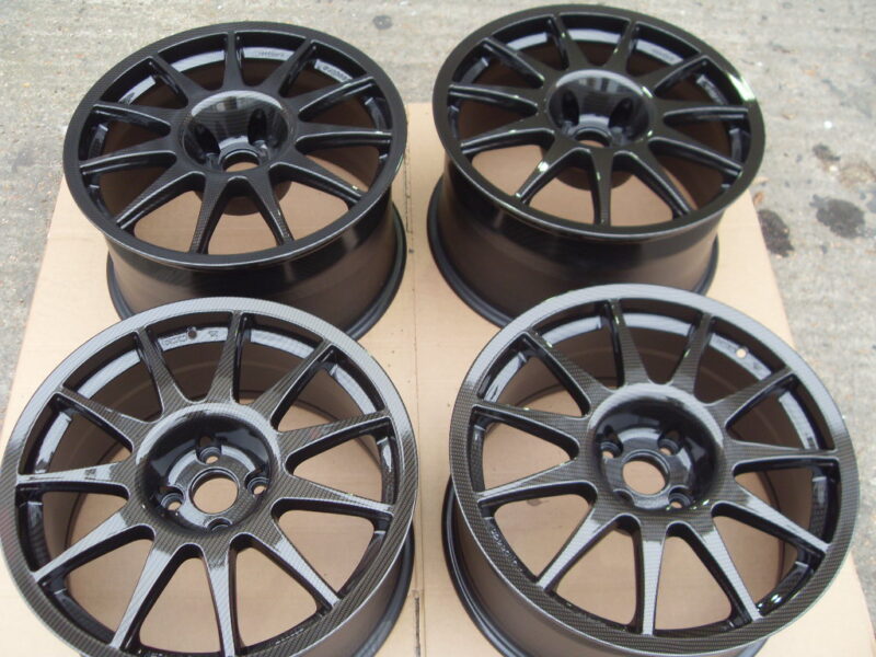 Car alloy wheels coated in carbon fibre painted black