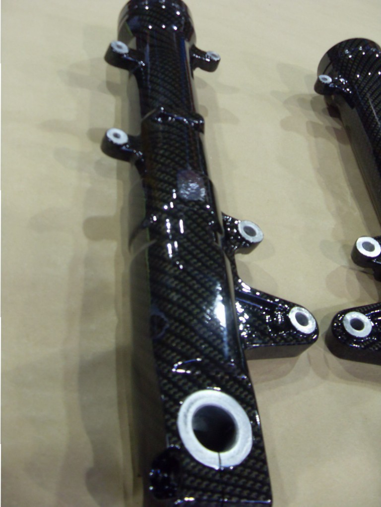 Motorbike parts coated in carbon fibre hydrographic film painted black