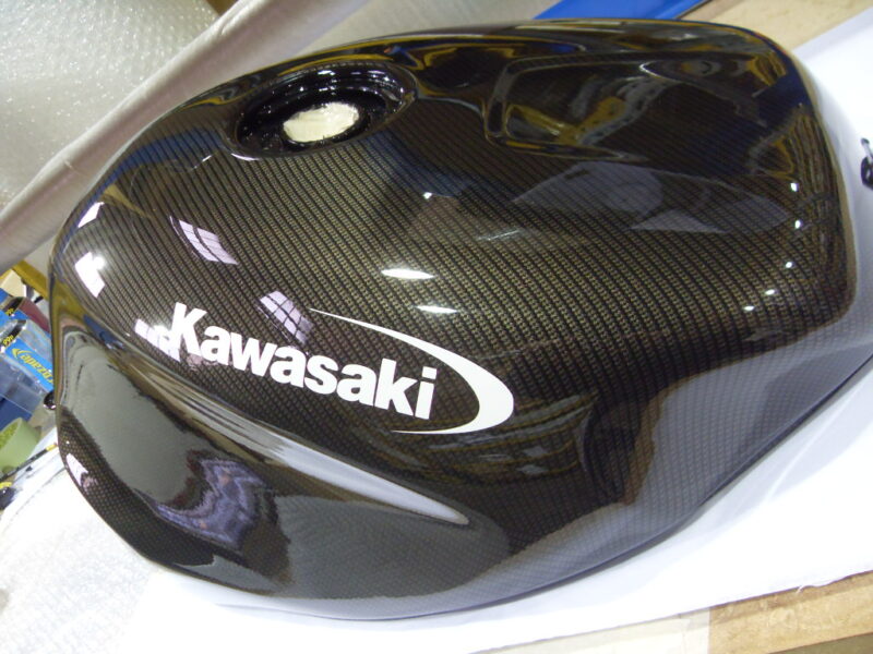 Motorbike tank coated in carbon fibre hydrographic film painted black
