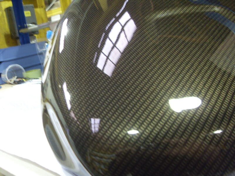 Motorbike tank coated in carbon fibre hydrographic film painted black