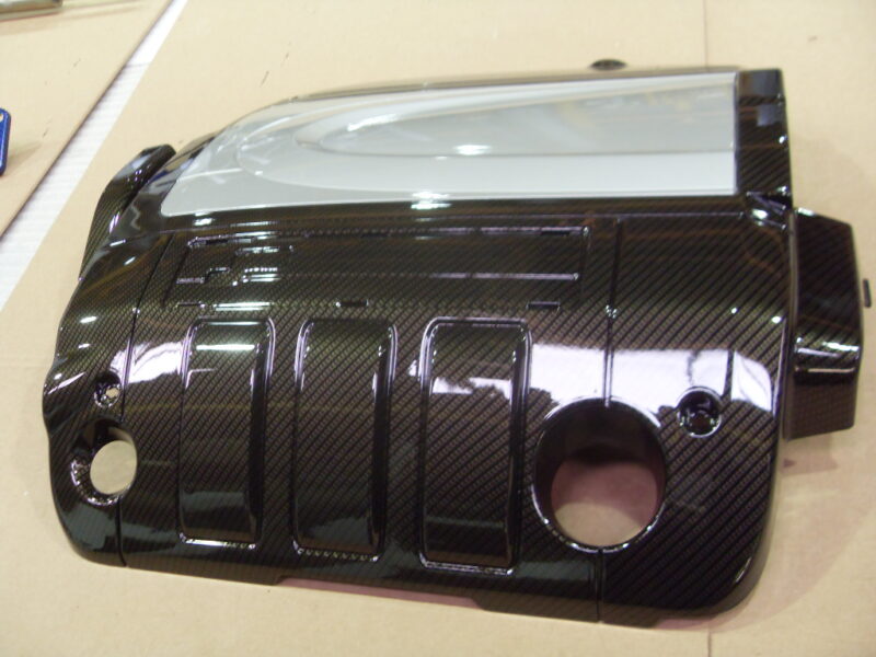 Engine cover coated in carbon fibre hydrographic film painted black
