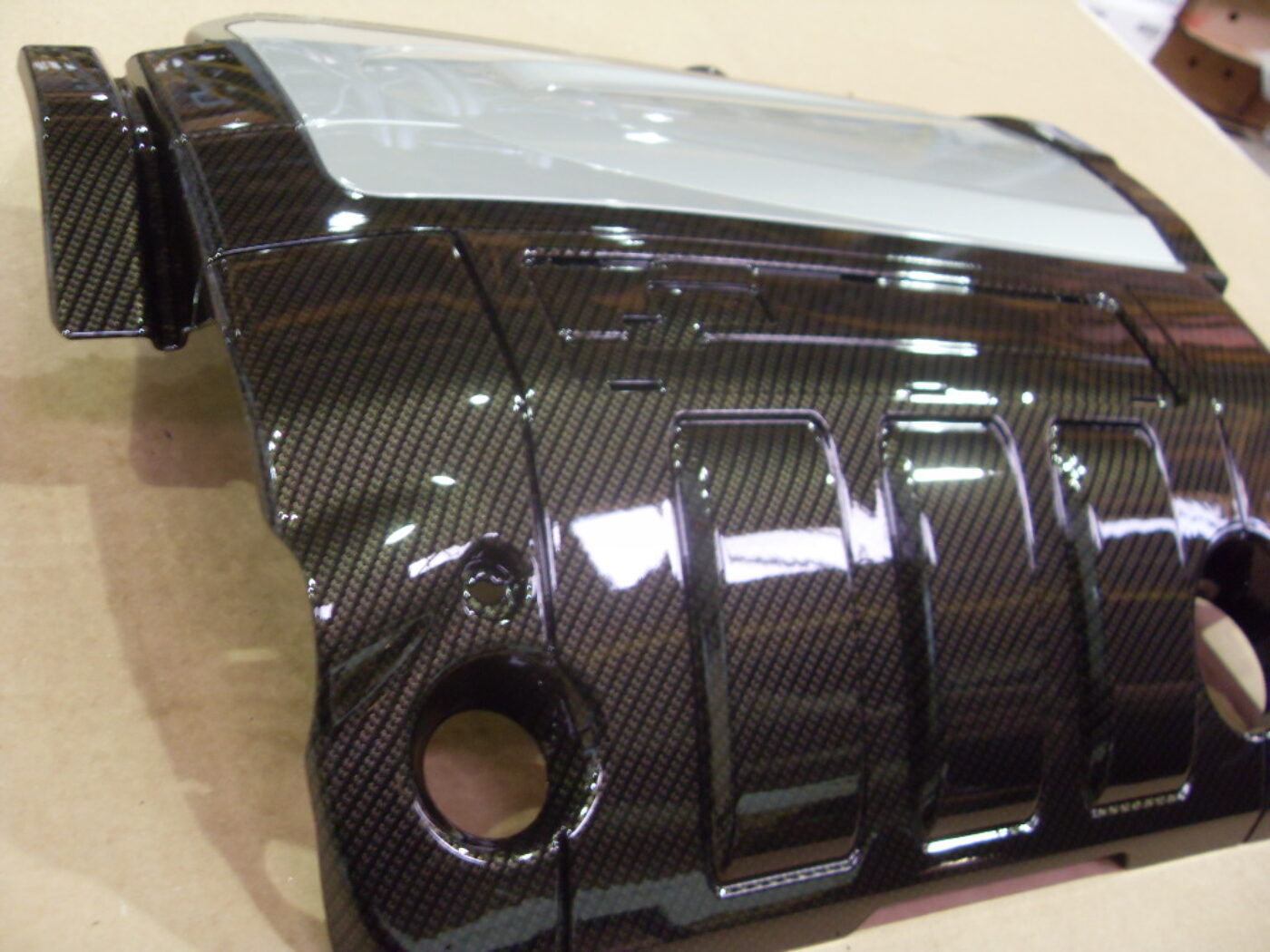 Engine cover coated in carbon fibre hydrographic film painted black