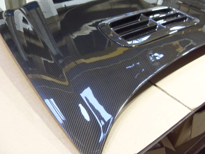 Car hood coated in carbon fibre hydrographic film painted grey