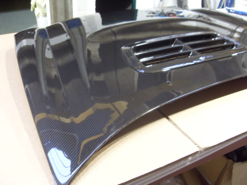 Car hood coated in carbon fibre hydrographic film painted grey