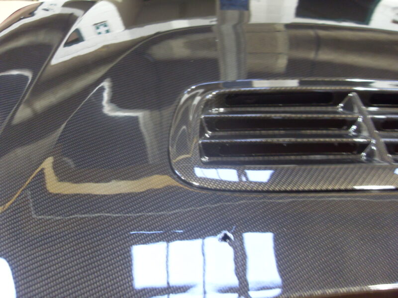 Car hood coated in carbon fibre hydrographic film painted grey