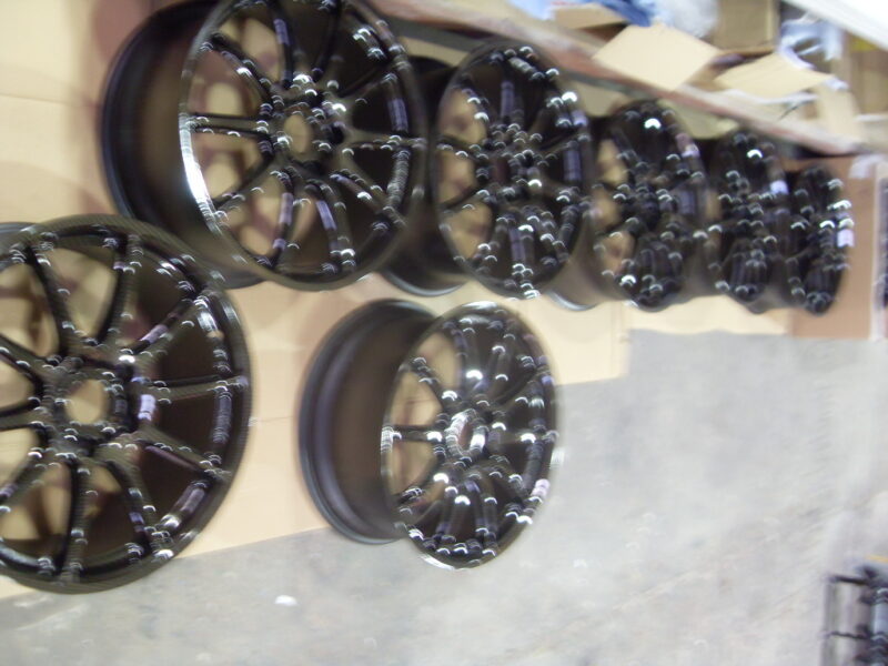 Car alloy wheels coated in carbon fibre painted black