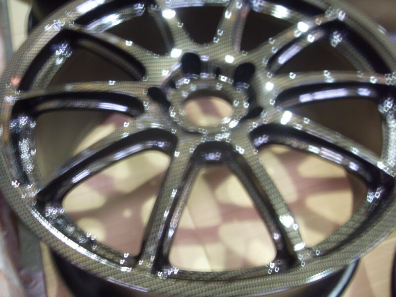 Car alloy wheels coated in carbon fibre painted black