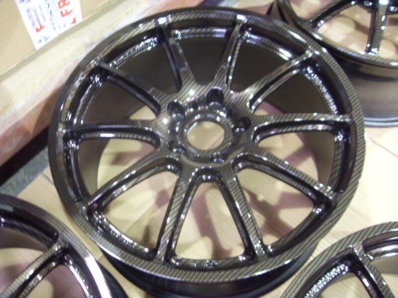 Car alloy wheels coated in carbon fibre painted black