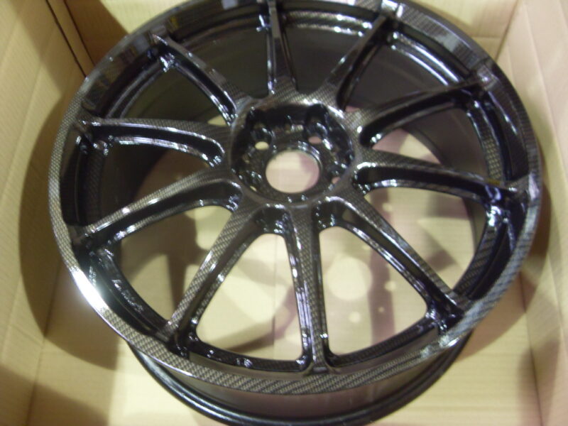 Car alloy wheels coated in carbon fibre painted black