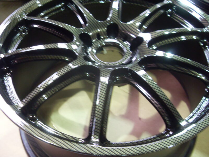 Car alloy wheels coated in carbon fibre painted black