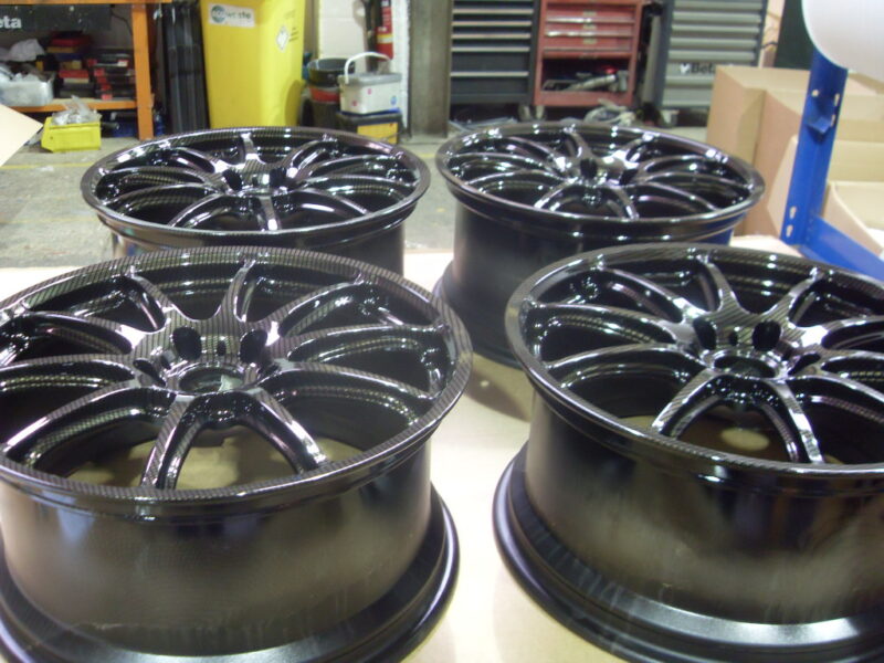 Car alloy wheels coated in carbon fibre painted black