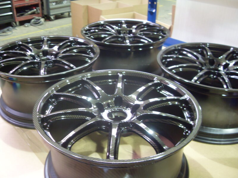 Car alloy wheels coated in carbon fibre painted black