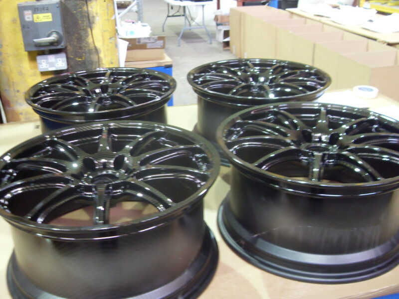 Car alloy wheels coated in carbon fibre painted black